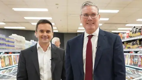 PA Media Richard Walker stands next to Prime Minister Sir Keir Starmer in an Iceland