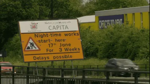 A yellow sign explaining the road closures and restrictions on the coast road. 