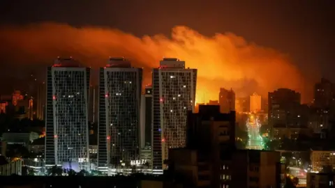 Reuters Smoke billows in the night sky above Kyiv during a Russian drone attack. Photo: 10 July 2025