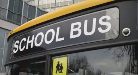 School bus front including animated image of children walking