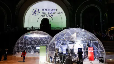 Getty Images Two large clear indoor domes in front of the logo which reads "Some pour l'action Sur l'IA"