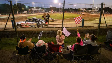 Spectators applaud the winner of a banger race at Arlington Stadium on August 09, 2023.