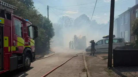 Leicestershire Fire and Rescue Service Fire engines on a road with smoke in the air