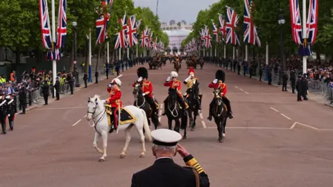 PA Media King Charles III takes the salute from the military procession