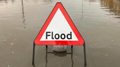 Flood warning sign in floodwater.