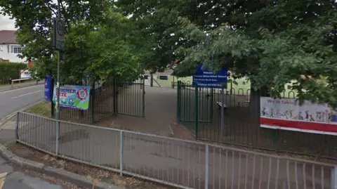 Google A Google Street image of the front gates of the school. There is a blue sign which says "Thames Ditton Infant School".