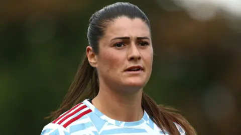 Ross Halls Holly Turner, wearing her Hashtag United jersey, which is patterned white and red. 