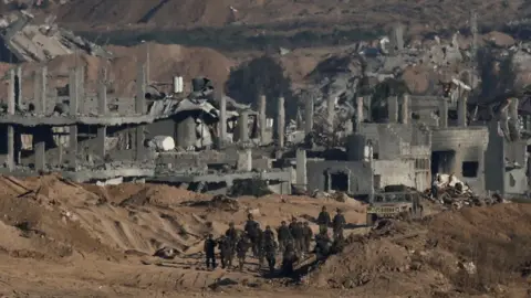 Reuters Israeli soldiers operate in Gaza, as seen from the Israeli side of the border (6 July 2025)