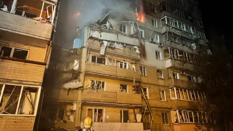 Ukraine's emergency service DSNS A firefighter looks at a partially destroyed residential house in Kyiv, following a Russian drone attack. Photo: 7 September 2025