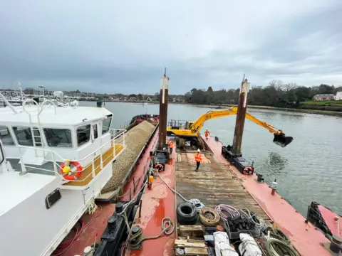 PA Media The team working on the River Hamble