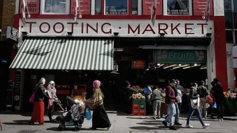 Getty Images People walk past the busy Tooting Market.