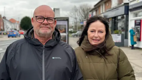 David Reeves/BBC Man and woman look into camera lens.