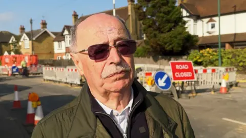 David Hackett stands next to roadworks on Loose Road, Maidstone