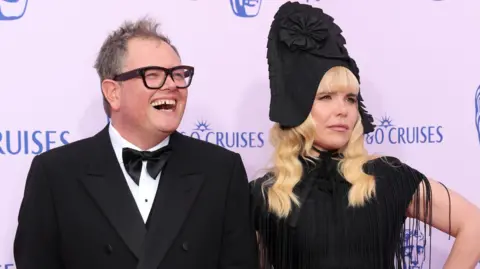 Getty Images Carr and Paloma Faith, in an ornate tall black hat