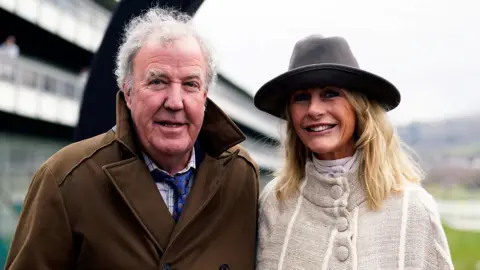 PA Media Jeremy Clarkson and Lisa Hogan on day four of the 2025 Cheltenham Festival at Cheltenham Racecourse. 
