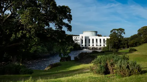 Drax The white art deco power station at Tongland next to a river and among trees and fields