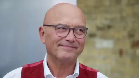 BBC/Shine TV A head and shoulders shot of Gregg Wallace. He is wearing a white shirt and a red waistcoat