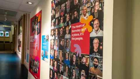 Provided Many of the portraits displayed in a collage style, accompanied by text reading: "The Heart of Barnsley isn't a place, it's the people."