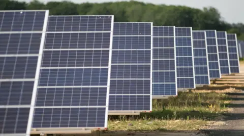 A close-up of a row of solar panels in a field.