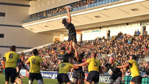 Getty Images Ben Gulliver playing rugby. He is highest and catching the ball in a large stadium. 