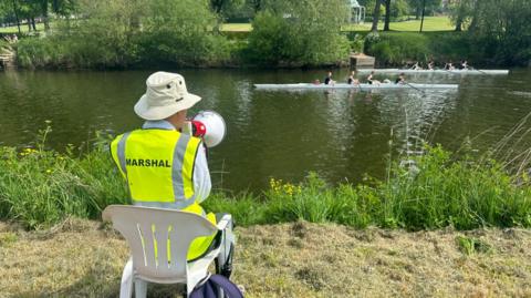 A marshal watches the rowers
