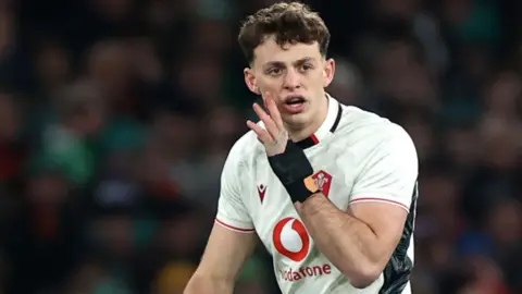 Louie Hennessey shouts with hand to mouth during a Wales game