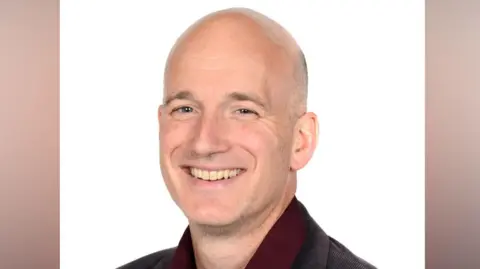 Jack Jacobs smiling as he sits for a portrait photography.