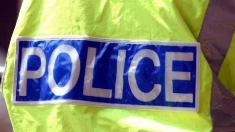 BBC A logo on the back of a florescent yellow jacket which reads 'police' in capital letters