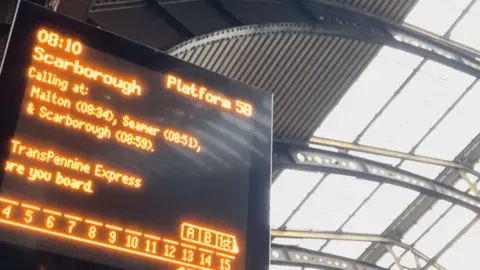 A train information board stating the time, platform and train for Scarborough