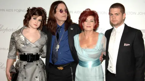 PA Media From left to right - Kelly, Ozzy, Sharon and Jack Osbourne pose for a picture at an event.