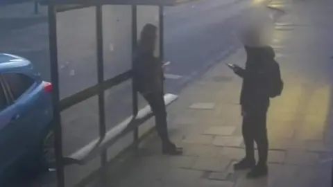 A surveillance image from Northumbria Police shows Holly Newton leaning on a bus stop in Hexham while the boy who tried to attack her stands just metres away.