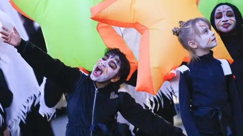 Stuart Walker Children with face paint dressed up for a costume parade