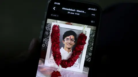 Prashant Patel, 45, shows a photo of his 17-year-old son Kahaan Patel, who took his own life ahead of the NEET exam retest, in Ahmedabad