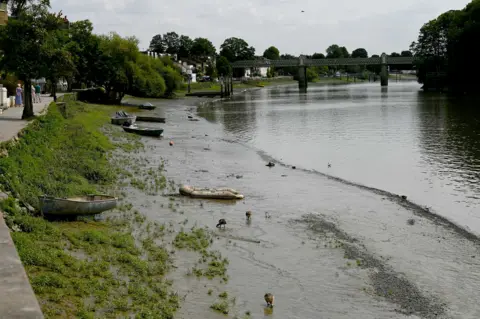 Anadolu via Getty Images Boats are seen stranded on the exposed riverbed of the River Thames as water levels drop amid hot and dry weather conditions in London, United Kingdom, on July 24, 2026.
