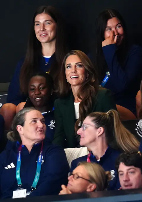 PA Media The Duchess of Rothesay in a crowd watching a netball match - she is smiling and is gazing upwards