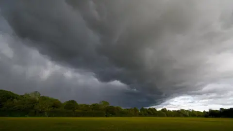 SMUpix/BBC Weather Watchers Dark strom clouds billow above an open green field