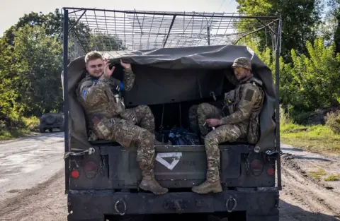 EPA Ukrainian servicemen ride in the back of a military vehicle not far from the Ukraine - Russian border