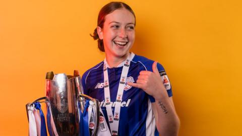 Molly Kehoe poses with the league trophy 