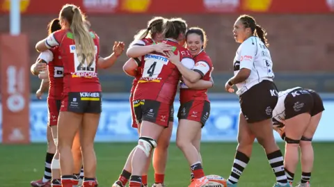 PA Media Gloucester-Hartpury players celebrate victory by embracing each other on the pitch after beating Bristol Bears at Kingsholm in Premiership Women's Rugby semi-final match at Kingsholm