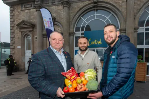 City of Wolverhampton Council Three men hold a box of food outside the Queen's Building in Wolverhampton
