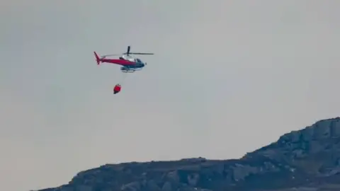 Pat O'Neill A helicopter is seen above a mountain