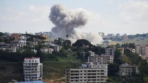 Smoke rising in a semi-built-up area in southern Lebanon following an Israeli strike 