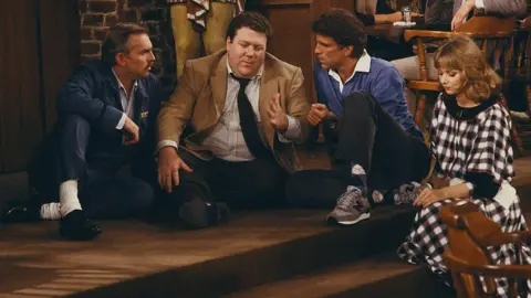 Getty Images A scene from Cheers showing John Ratzenberger as Cliff Clavin, George Wendt as Norm Peterson, Ted Danson as Sam Malone, Shelley Long as Diane Chambers