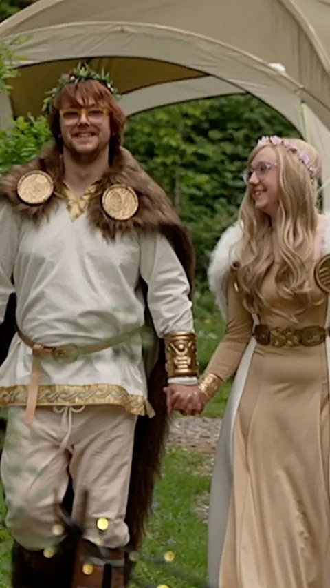 Couple in fantasy costumes holding hands and smiling