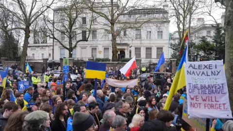 PA Media sekelompok pengunjuk rasa - memegang bendera Ukraina dan pembacaan poster 