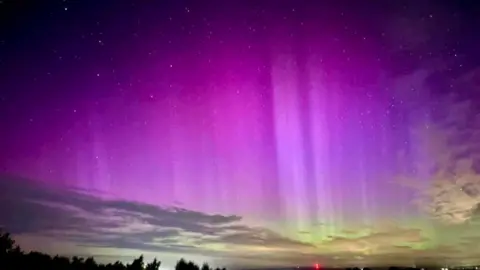 Matt Stead Northern Lights over Rurdean Hill in the Forest of Dean. The sky is a mixture of purple and light green