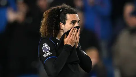 Marc Cucurella pulls his shirt up over his mouth after defeat at Brighton