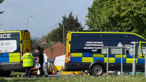 Emergency services staff and vehicles on Aberthaw Road.