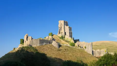 Getty Images Looking up at the famous 11th century hilltop ruins of Corfe Castle in Dorset.