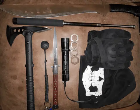 Crown Office A cache of weapons, including a knife, axe and stun baton laid on a floor